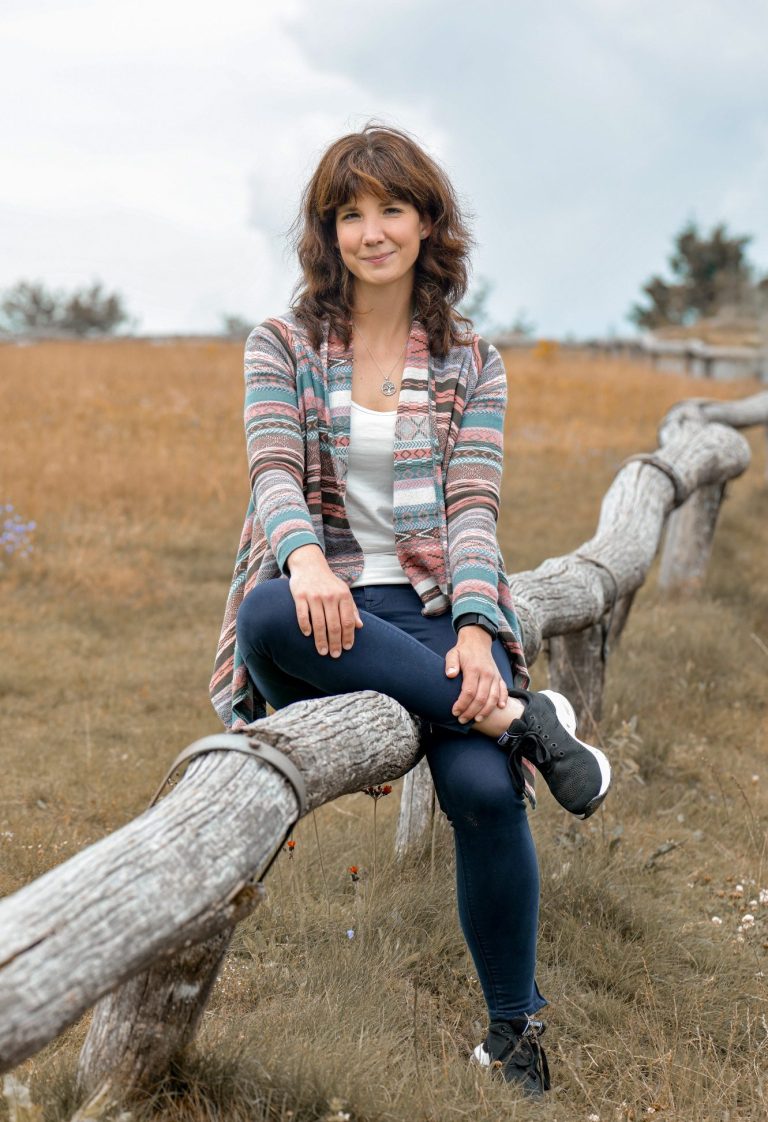 Zwei Kinder streicheln Pferdeköpfe in der Reittherapie, ein lachendes Mädchen vorn im Bild