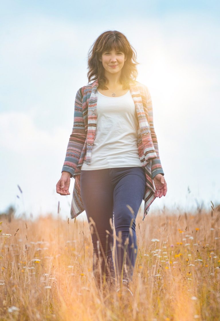 Zwei Kinder streicheln Pferdeköpfe in der Reittherapie, ein lachendes Mädchen vorn im Bild